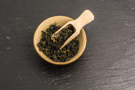 green tea in vintage spoons on dark wooden background with copyspaceの写真素材