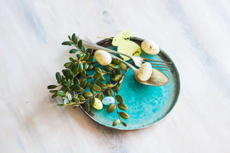 Table setting for Easter dinner with eggs on rustic wooden tableの写真素材