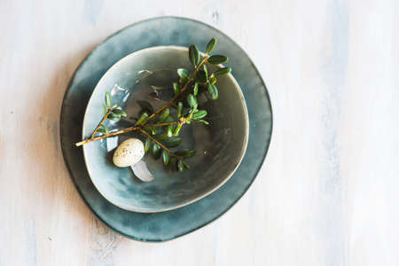 Table setting for Easter dinner with eggs on rustic wooden tableの写真素材