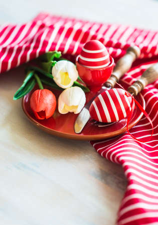 Table setting for Easter dinner with eggs on rustic wooden tableの写真素材