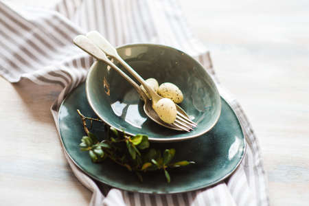 Table setting for Easter dinner with eggs on rustic wooden table