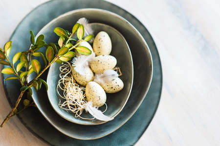 Table setting for Easter dinner with eggs on rustic wooden tableの写真素材