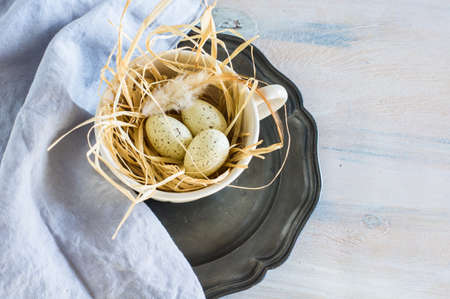 Table setting for Easter dinner with tulips and eggs on rustic wooden table