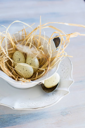 Table setting for Easter dinner with tulips and eggs on rustic wooden table