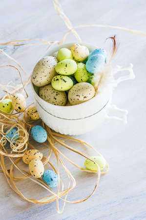 Table setting for Easter dinner with eggs on white wooden table