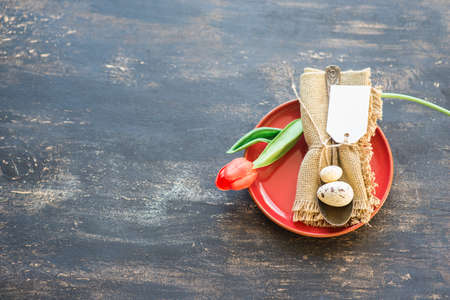 Table setting for Easter dinner with eggs on rustic wooden table