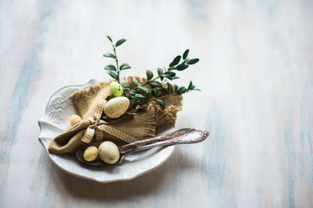 Table setting for Easter dinner with eggs on rustic wooden table