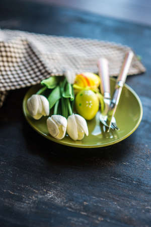 Table setting for Easter dinner with eggs on rustic wooden table