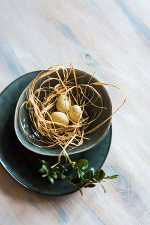 Table setting for Easter dinner with eggs on rustic wooden table