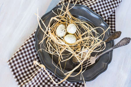 Table setting for Easter dinner with tulips and eggs on rustic wooden table
