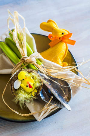 Table setting for Easter dinner with eggs on white wooden table