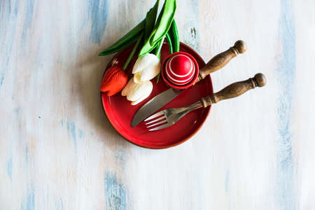Table setting for Easter dinner with eggs on rustic wooden tableの写真素材