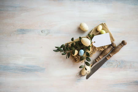 Table setting for Easter dinner with eggs on rustic wooden tableの写真素材