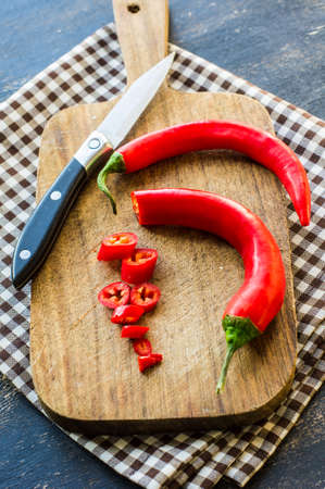 Organic food - hot chilli pepper on dark cutting boardの写真素材