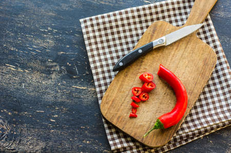 Organic food - hot chilli pepper on dark cutting boardの写真素材