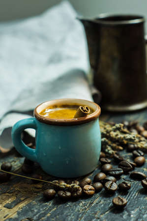 Rustic mug with coffee on dark wooden tableの写真素材