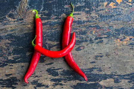 Organic food - hot chilli pepper on dark cutting boardの写真素材