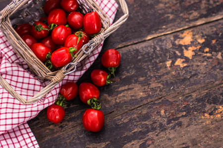 Fresh ripe organic cherry tomatoes and bright ceramic plates on dark wooden table wt copyspaceの写真素材