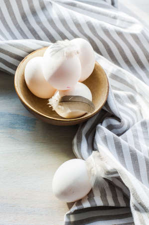 eggs in a porcelain bowl on the rustic wooden table