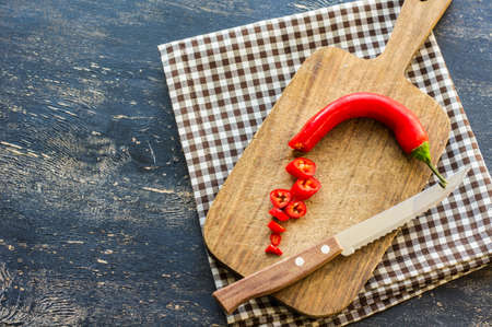 Organic food - hot chilli pepper on dark cutting boardの写真素材