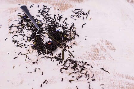 Spoon with floral tea on vintage dark board with copyspaceの写真素材