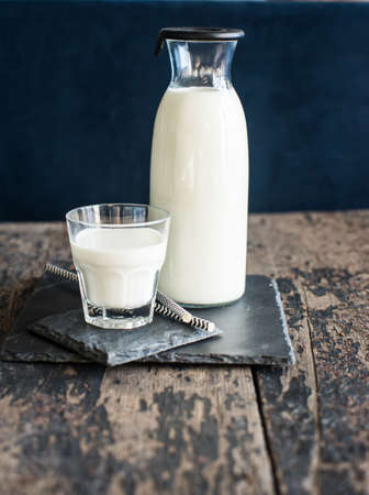 Healthy food concept: Bottle of milk  on dark wooden tableの写真素材
