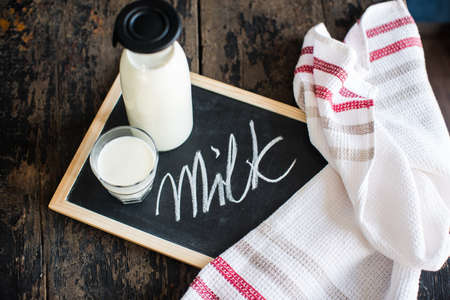 Healthy food concept: Bottle of milk  on dark wooden tableの写真素材