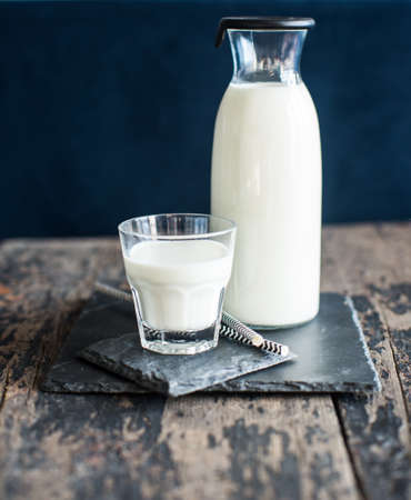 Healthy food concept: Bottle of milk  on dark wooden tableの写真素材