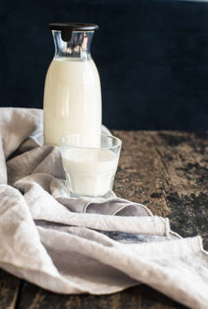 Healthy food concept: Bottle of milk  on dark wooden tableの写真素材