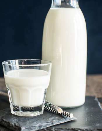 Healthy food concept: Bottle of milk  on dark wooden tableの写真素材