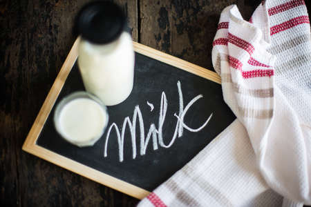 Healthy food concept: Bottle of milk  on dark wooden tableの写真素材