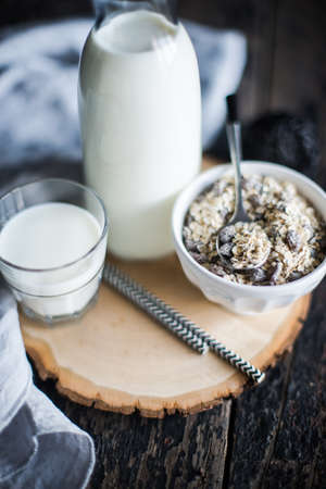 Bottle of milk and oatmeal on dark wooden table as a healthy breakfast conceptの写真素材