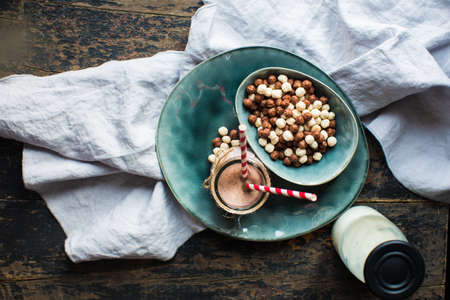 Healthy breakast corn flakes in a bowl and glass of milk on rustic wooden table with copyspace