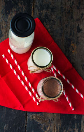 Glass of milk on dark wooden rustic table with copyspaceの写真素材