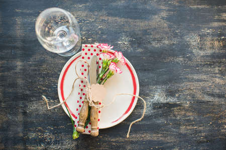 Festive table setting for spring dinner with fresh flowers on dark wooden table