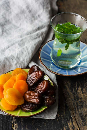 Eastern tea with mint and arabian sweets on wooden rustic tableの写真素材