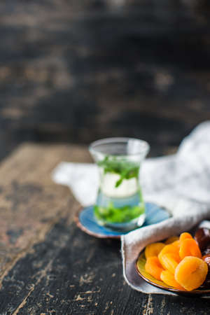 Eastern tea with mint and arabian sweets on wooden rustic tableの写真素材