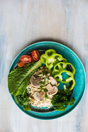 Healthy food concept with mushrooms in sour sauce and fresh vegetables on wooden tableの写真素材