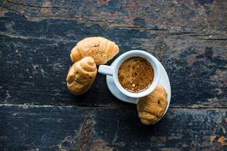 Cup of coffee and sweets on dark rustic backgroundの写真素材