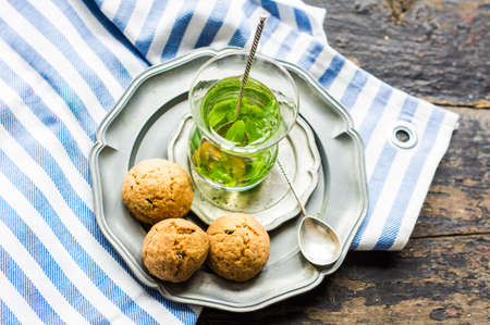 Eastern tea with mint and arabian sweets on wooden rustic tableの写真素材