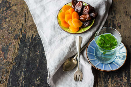 Eastern tea with mint and arabian sweets on wooden rustic tableの写真素材