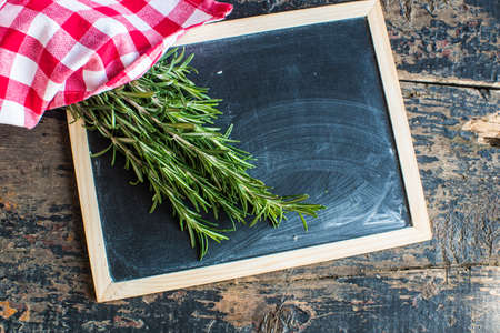 Fresh rosemary spice on dark wooden board with copyspaceの写真素材