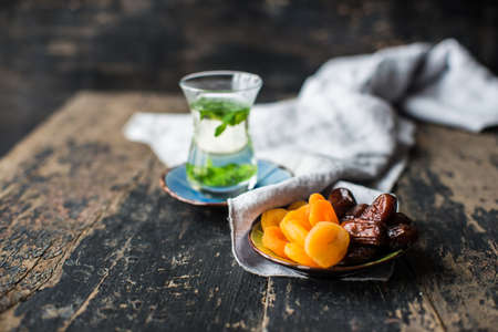 Eastern tea with mint and arabian sweets on wooden rustic tableの写真素材