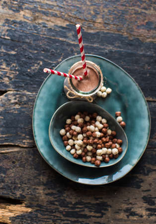 Healthy breakast corn flakes in a bowl and glass of milk on rustic wooden table with copyspaceの写真素材