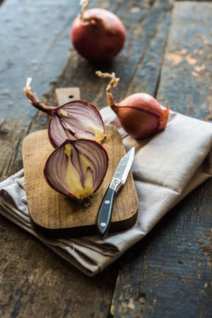 Organic food concept with fresh red onion on dark wooden tableの写真素材