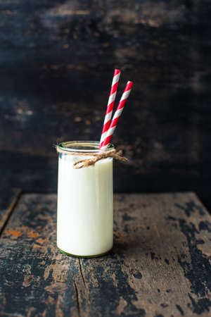 Glass of milk on dark wooden rustic table with copyspaceの写真素材