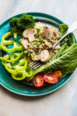 Healthy food concept with mushrooms in sour sauce and fresh vegetables on wooden tableの写真素材