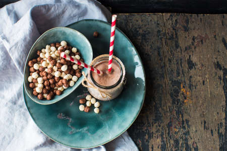 Healthy breakast corn flakes in a bowl and glass of milk on rustic wooden table with copyspaceの写真素材