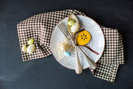 Festive table setting for Easter dinner on wooden rustic table