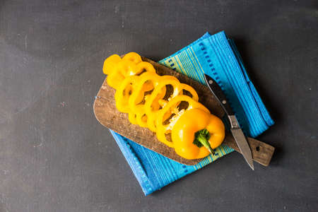 Healthy food concept yellow  sliced bell pepper vegetable on a cutting boardの写真素材